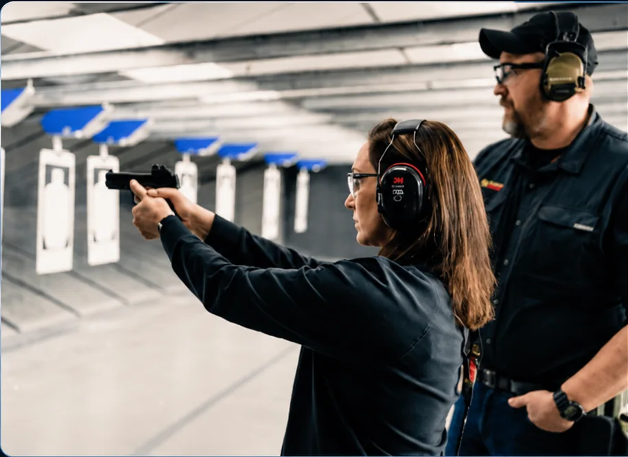 Instructor supervising a student during private handgun training at an indoor range